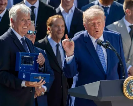 Donald Trump holds up a World Series championship ring gifted to him by Dodgers owner Mark Walter.