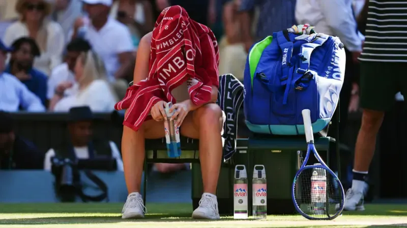 Linda Noskova covers her head with a towel