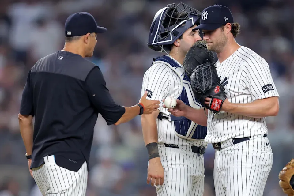 Jul 17, 2026; Bronx, New York, USA; New York Yankees starting pitcher Gerrit Cole (45) hands the ball to manager Aaron Boone (17) during a pitching change during the seventh inning against the Los Angeles Dodgers at Yankee Stadium. Mandatory Credit: Brad Penner-Imagn Images
