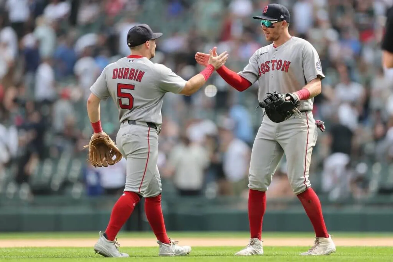 Red Sox players Caleb Durbin and Brett Harris high-five each other on the infield after Boston won a recent game against the Chicago White Sox.
