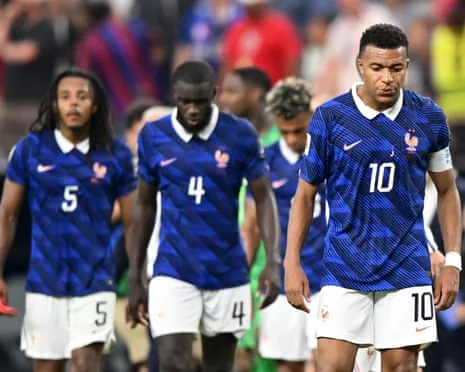 Kylian Mbappé, Dayot Upamecano and Jules Koundé of France look down in disappointment after losing the 2026 World Cup semi-final against Spain