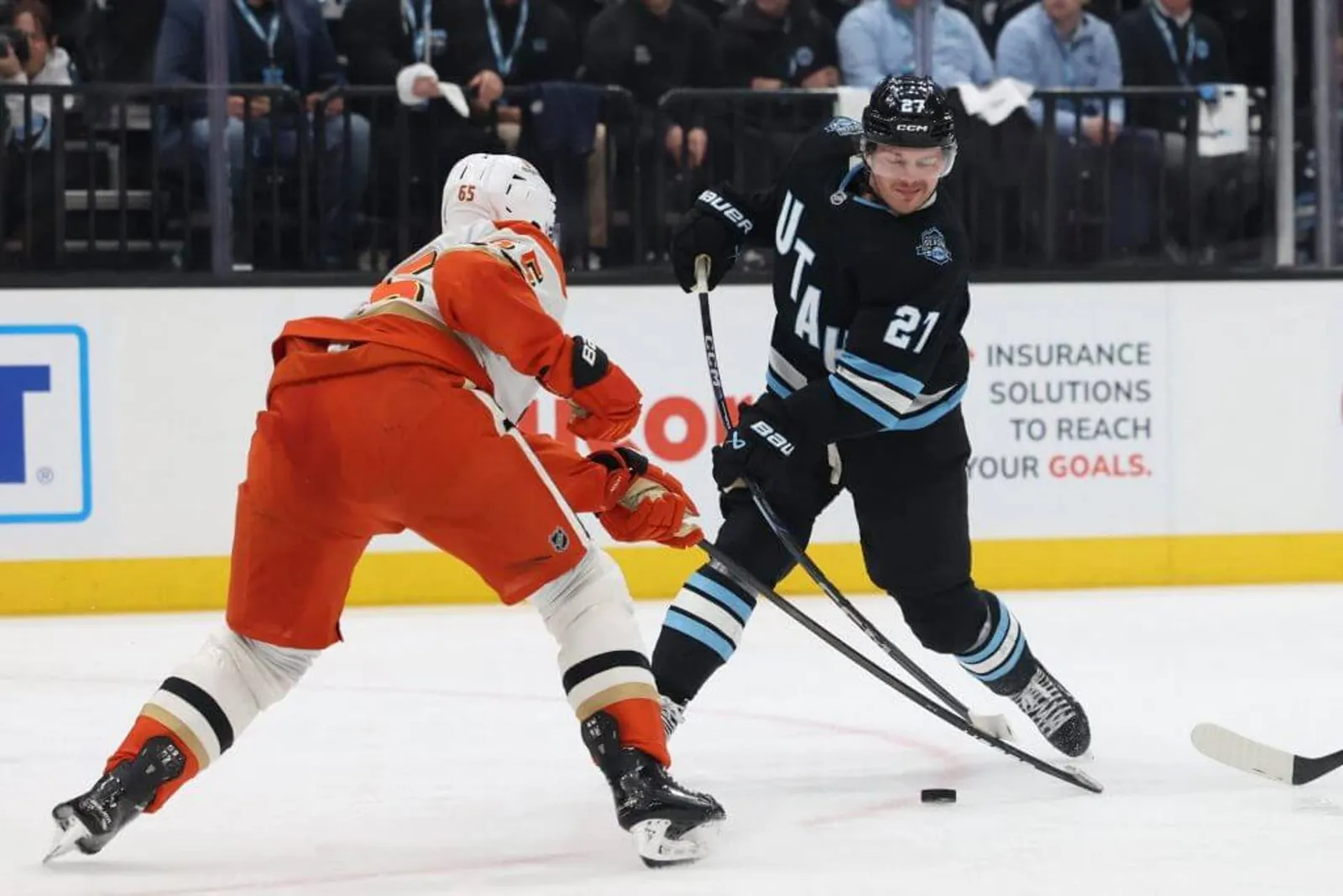 Utah's Barrett Hayton takes a shot with an Anaheim Ducks defenseman trying to block.